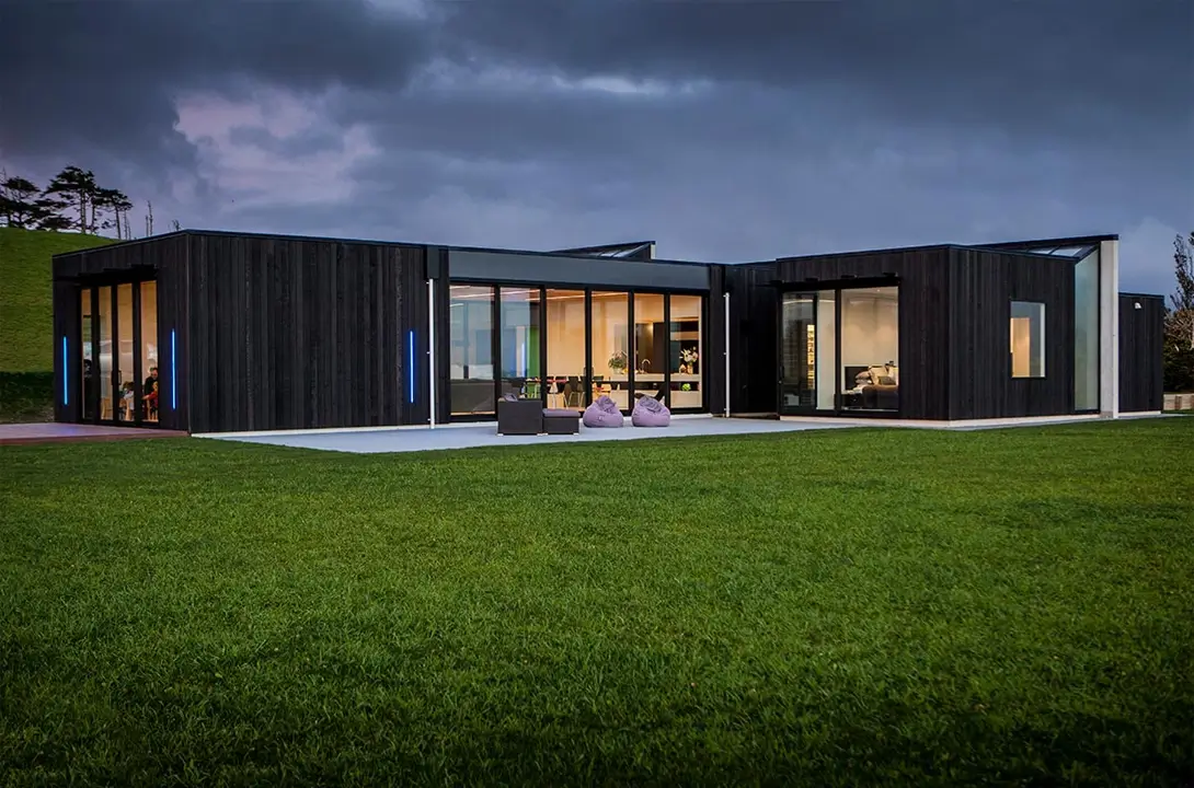 Black wooden house with a green lawn out front